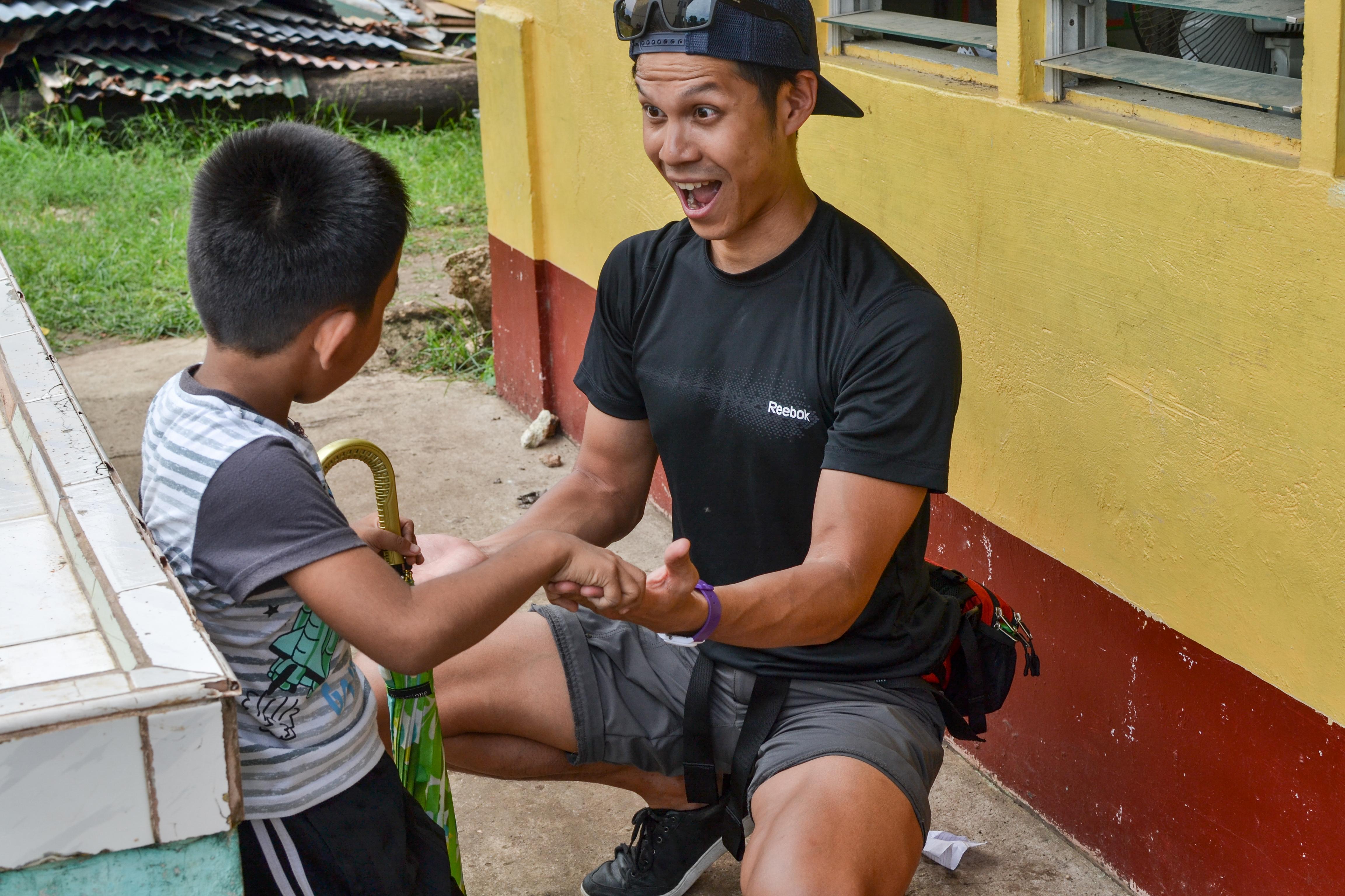 A Physiotherapy intern teaches a child's parents about exercises they can do at home in the Philippines. A child is treated at home by a student doing a Physiotherapy internship abroad in the Philippines.